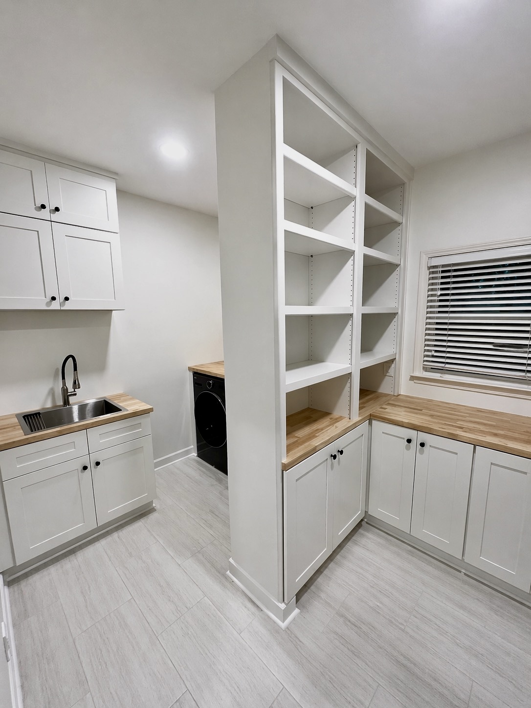 Built-in laundry and kitchenette with tall shelving